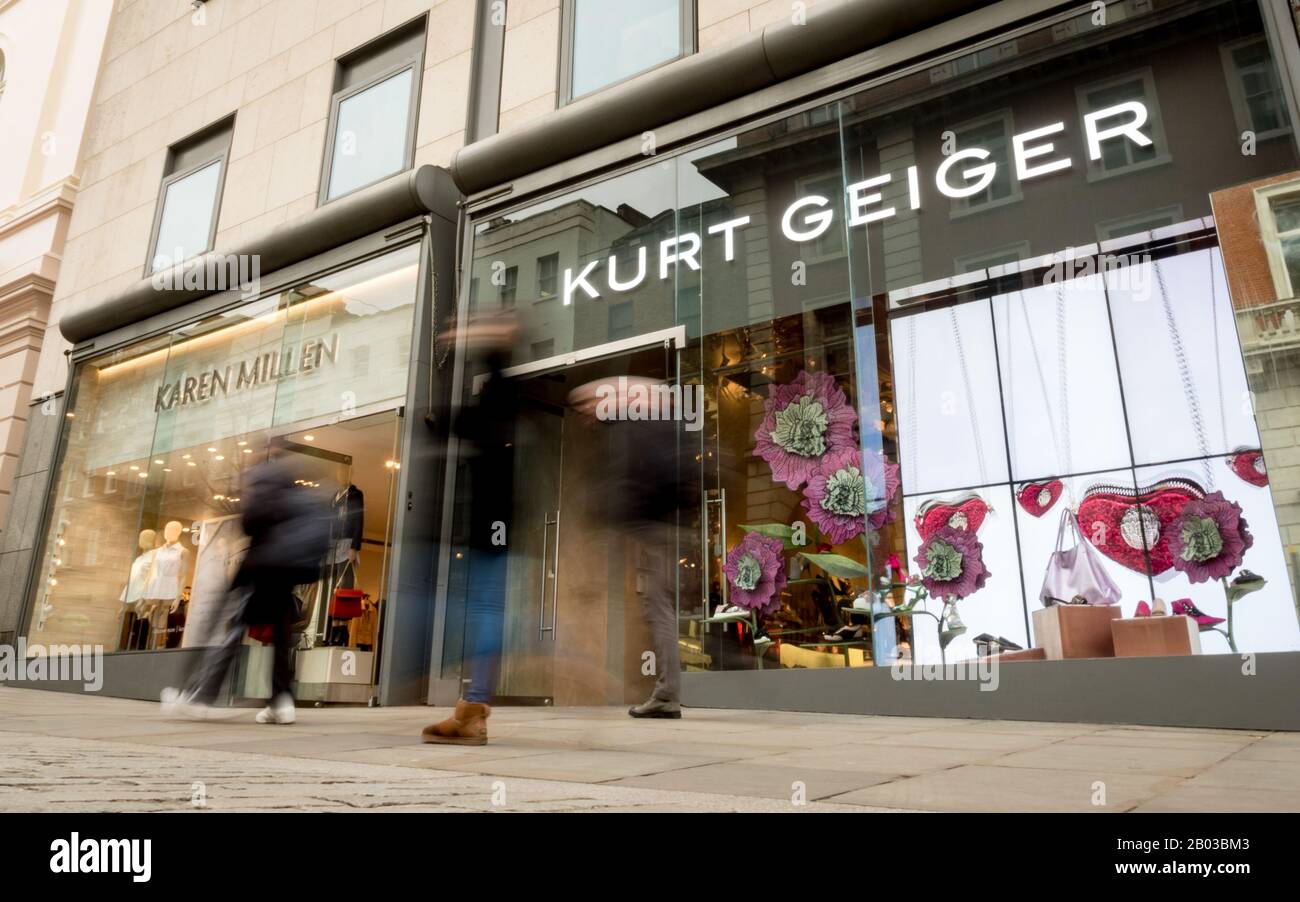Kurt Geiger store, Covent Garden, London. Blurred shoppers walking by the shop front to the fashion stores, Kurt Geiger and Karen Miller. Stock Photo