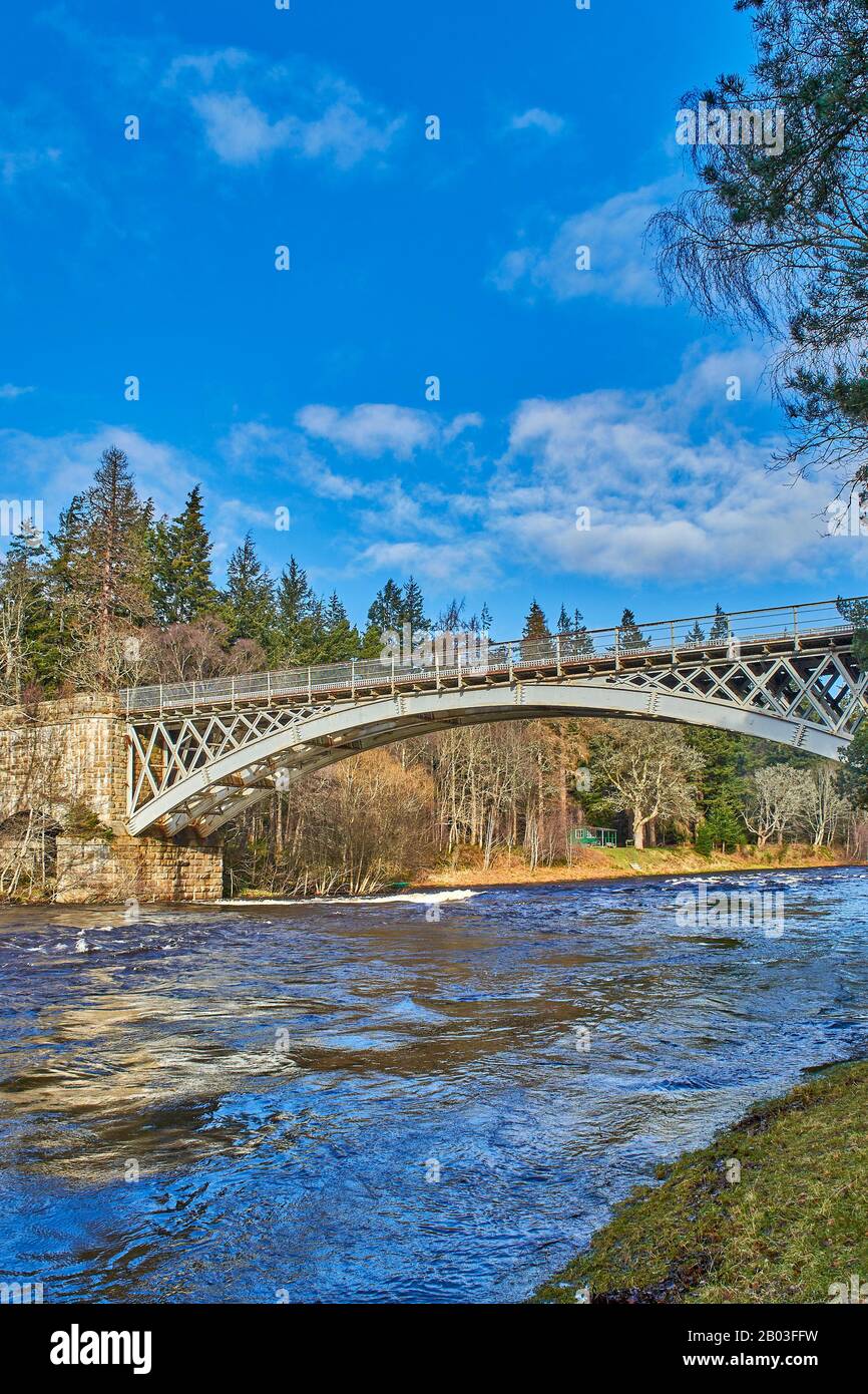 CARRON VILLAGE MORAY SCOTLAND A VIEW OF THE STRUCTURE OF UNIQUE CARRON ROAD AND OLD RAIL BRIDGE WHICH CROSSES THE RIVER SPEY AND A GREEN FISHING HUT Stock Photo