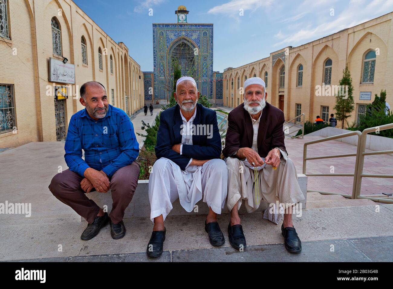 Local men with the Friday Mosque in the background, in Kerman, Iran Stock Photo