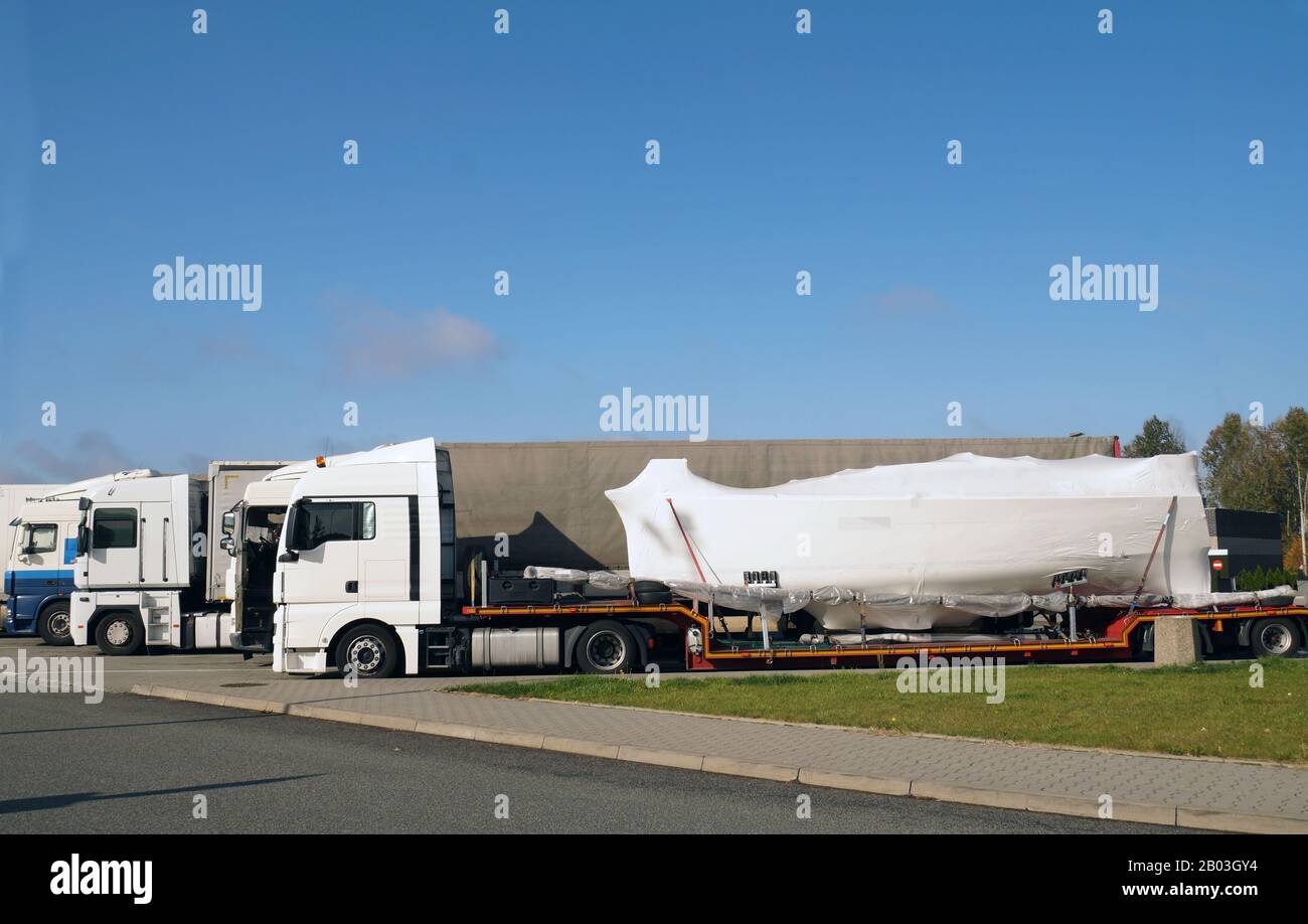 Land transport of boats and yachts. Truck with a special trailer for boat transport. Stock Photo
