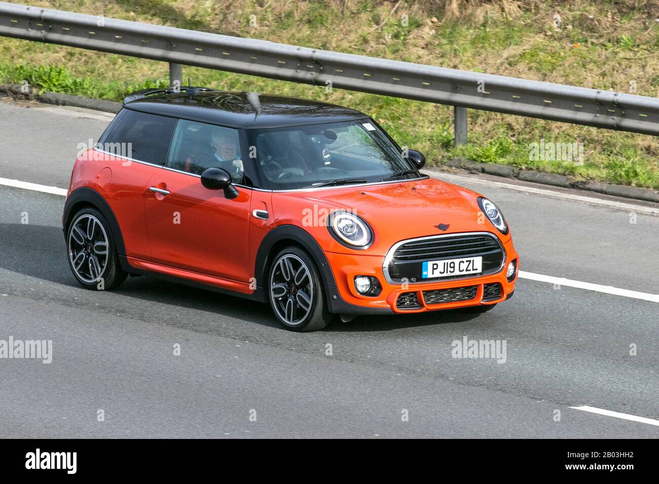 2019 orange Mini Cooper Sport; UK Vehicular traffic, road transport, modern vehicles, saloon cars, vehicle driving,  roads, motors, motoring south-bound on the M61 motorway highway Stock Photo