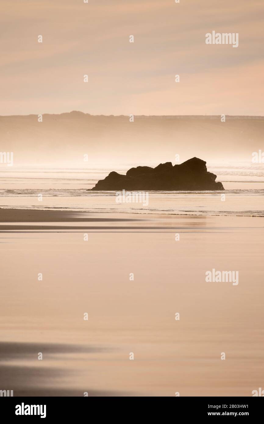 Rocky outcrop exposed by the low tide on the beach at Gwithian Sands, Cornwall. Stock Photo