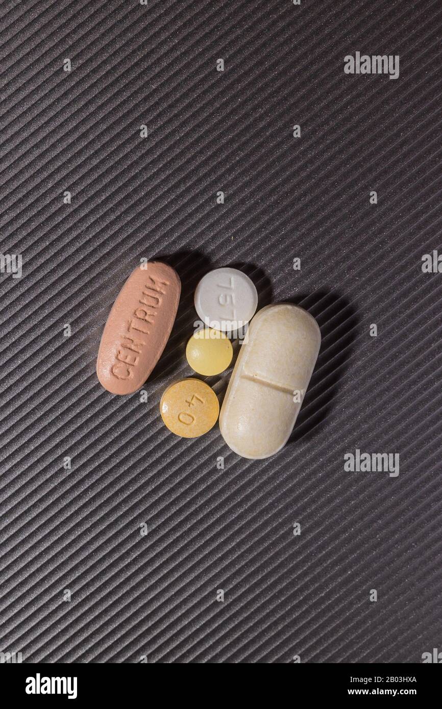 A daily ration of pills for an senior citizen. A vitamin, glucosamine, two blood pressure medications and a low dosage aspirin. Stock Photo