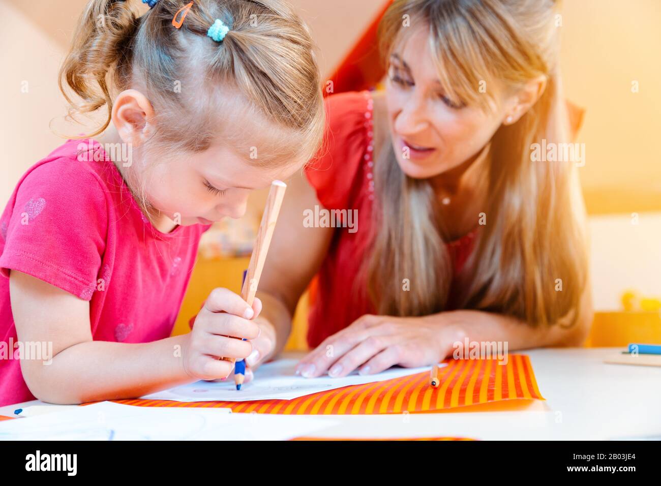 Children and play school teacher drawing together Stock Photo