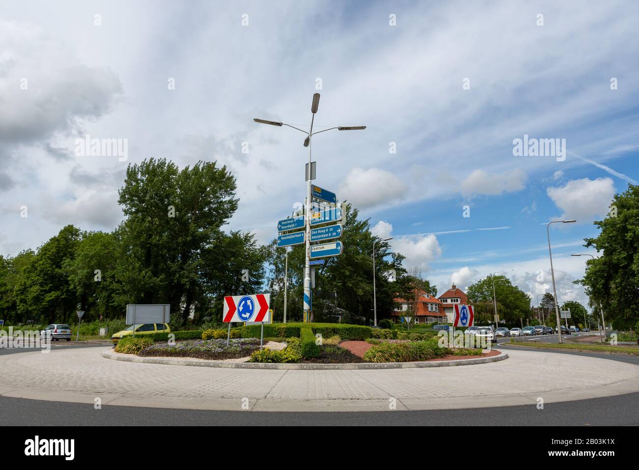 Cars entering a roundabout with traffic direction signs on the van Pallandtlaan in the village of Sassenheim in the Netherlands. Stock Photo