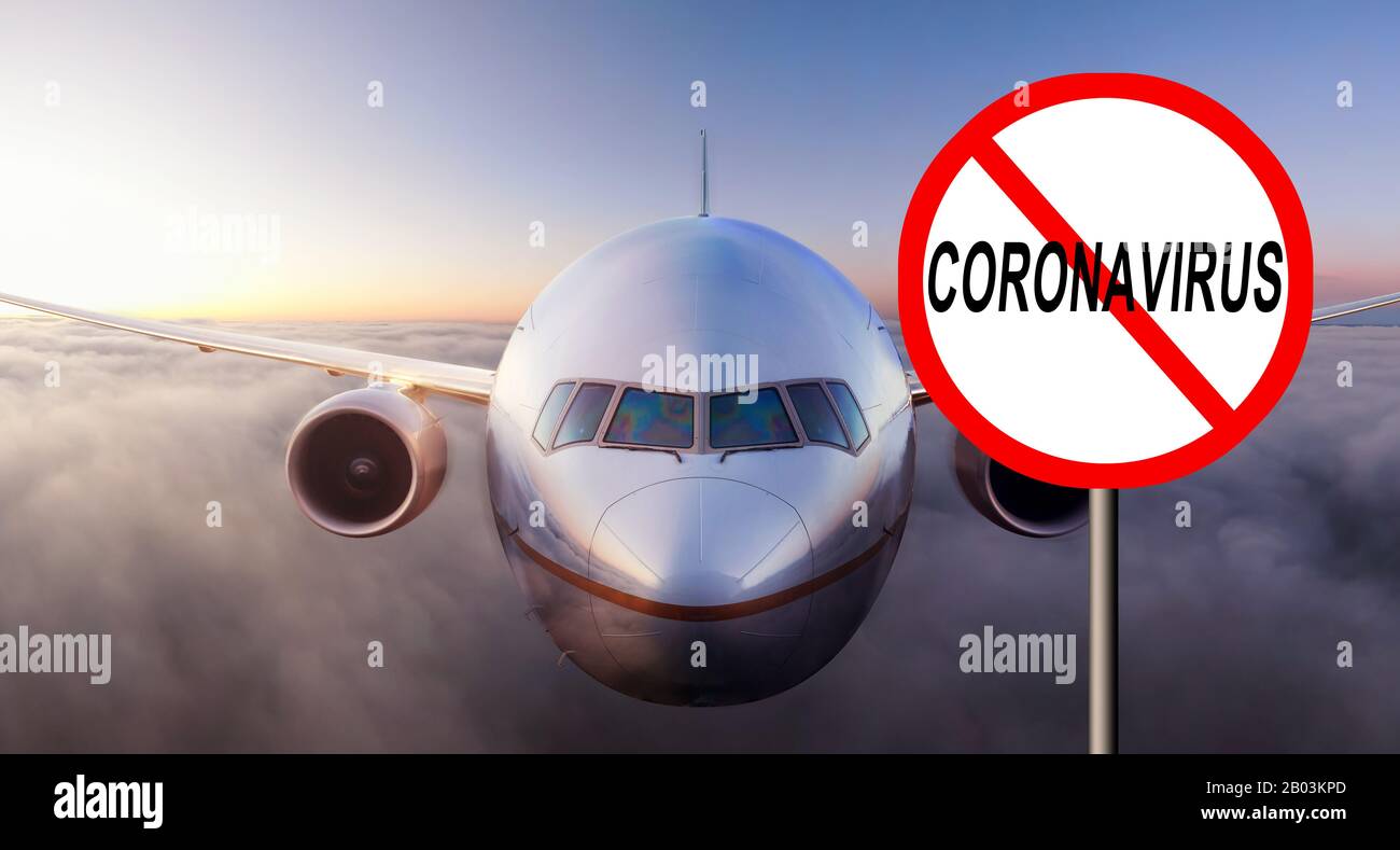 Coronavirus Flight ban Sign. Airplane flying above the clouds during colorful sunset or sunrise. Concept of safety, flight, security Stock Photo