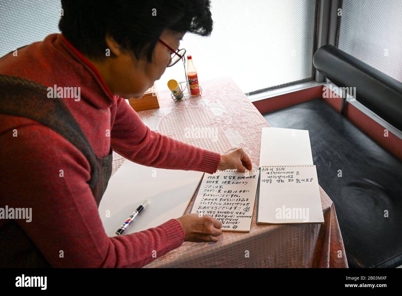 Seoul, South Korea. 18th Feb, 2020. Eom Han-gi, the owner of Pizza Sky in Seoul, shows off the guest book signed by visitors to her restaurant on Saturday, February 15, 2020. The pizza shop has become a tourist destination since its appearance in the Oscar-winning film 'Parasite' by director Bong Joon-ho. Photo by Thomas Maresca/UPI Credit: UPI/Alamy Live News Stock Photo