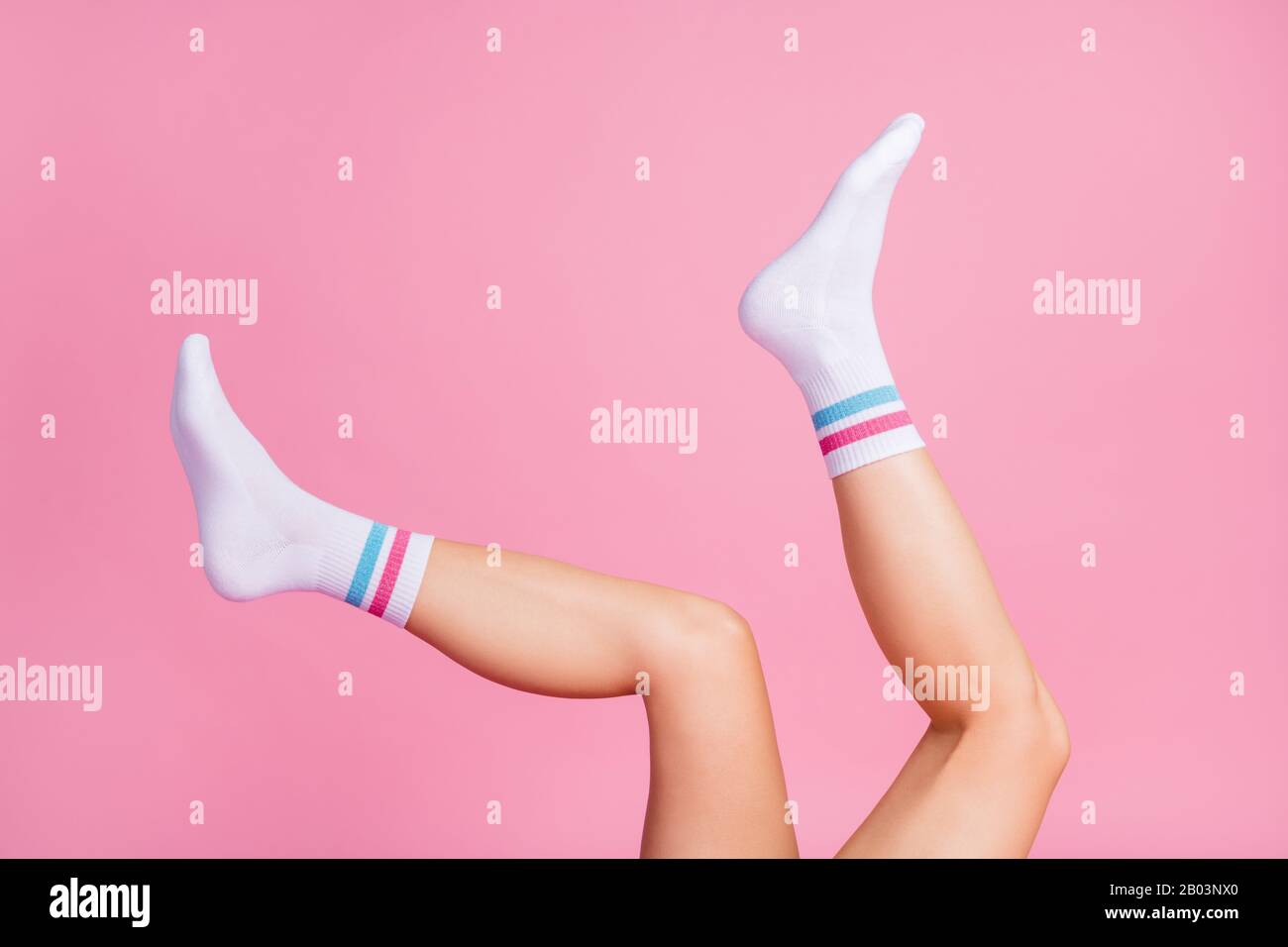 Legs And Feet With Cute Sock. Woman Wearing Pastel Pink And Yellow Socks  Raised Crossed Leg Isolated On Gray Background. Top View. Beauty And  Fashion Concept. Minimalism Fashionable Winter Set. Stock Photo