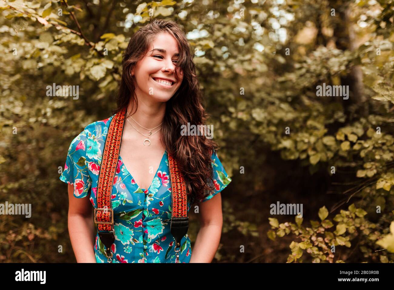 Young woman with analog camera wearing a dress in the forest Stock Photo