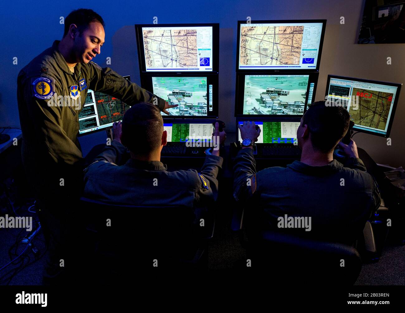 A U.S. Air Force Instructor Pilot, left, with student pilots during a Predator Reaper drone mission flight simulator at the 558th Flying Training Squadron, Joint Base San Antonio July 17, 2018 in San Antonio, Texas. Student pilots spend 85 days in the RPA Instrument Qualification course and 30 days in the RPA Fundamentals Course during the second phase of the Air Education and Training Command pilot curriculum. Stock Photo