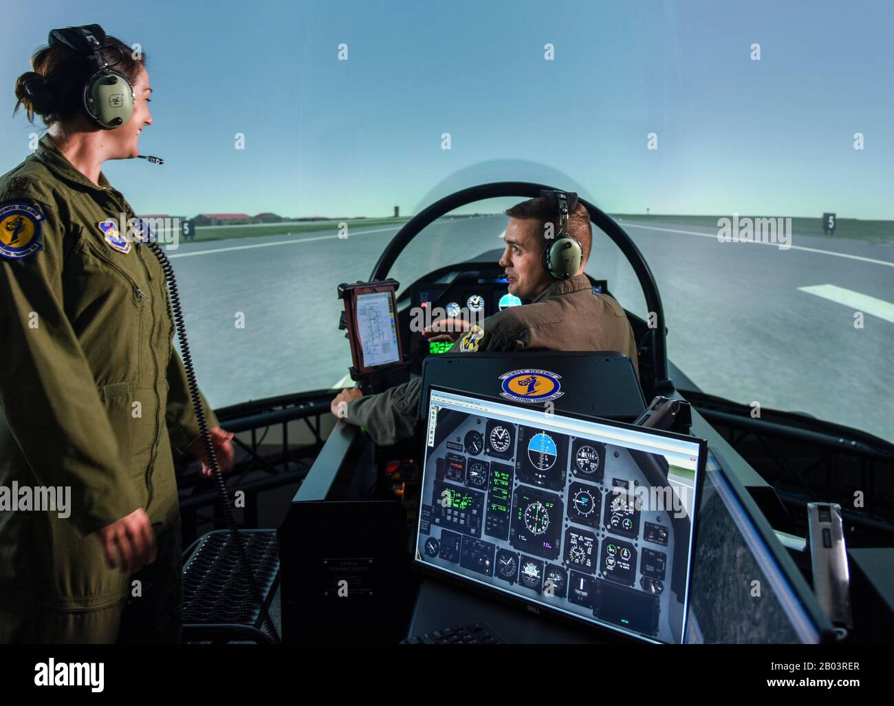 A U.S. Air Force Instructor Pilot, left, with a student pilot in the seat of a T-6 Flight Simulator part of the Predator Reaper drone training program at the 558th Flying Training Squadron, Joint Base San Antonio July 17, 2018 in San Antonio, Texas. Student pilots spend 85 days in the RPA Instrument Qualification course and 30 days in the RPA Fundamentals Course during the second phase of the Air Education and Training Command pilot curriculum. Stock Photo