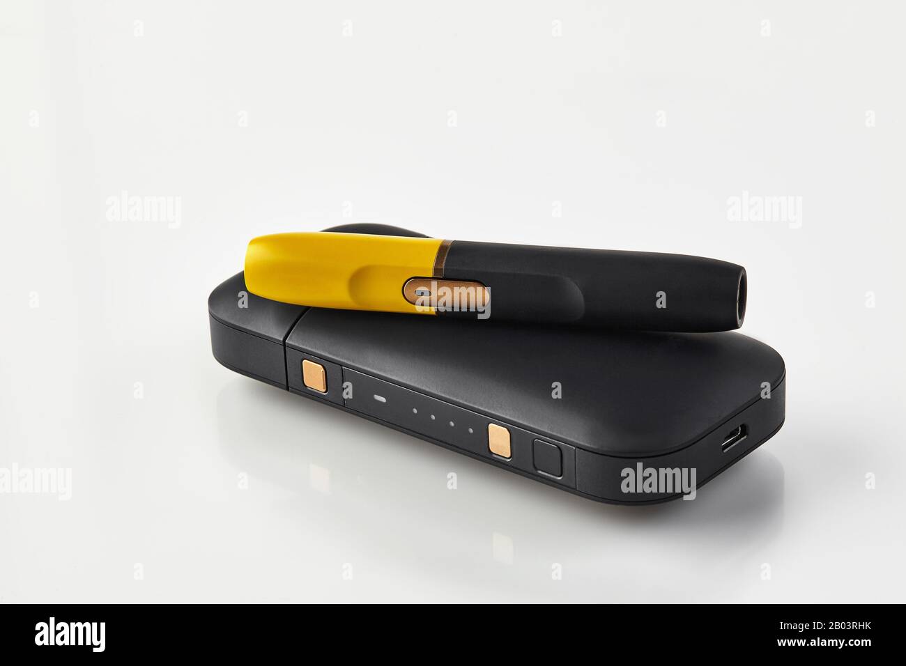 hi tec tobacco New generation black and yellow electronic cigarette is on battery,  isolated on white. Hi-tech heating tobacco system. Hybrid between analog  and elect Stock Photo