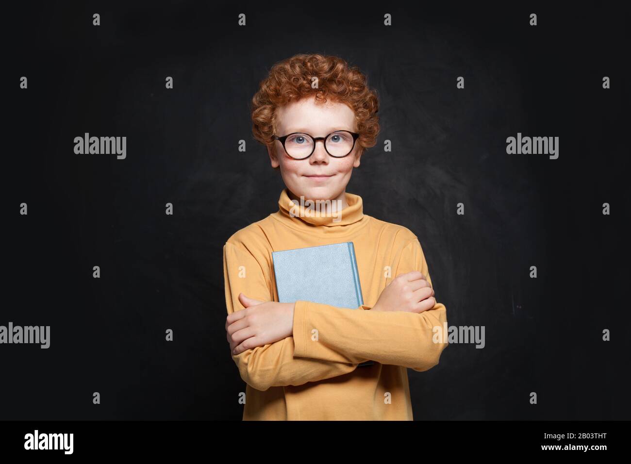 Portrait of school kid in glasses holding book Stock Photo