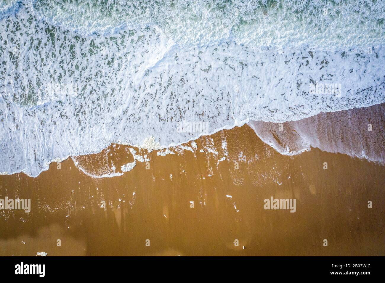 Waves breaking on beach aerial overhead Stock Photo