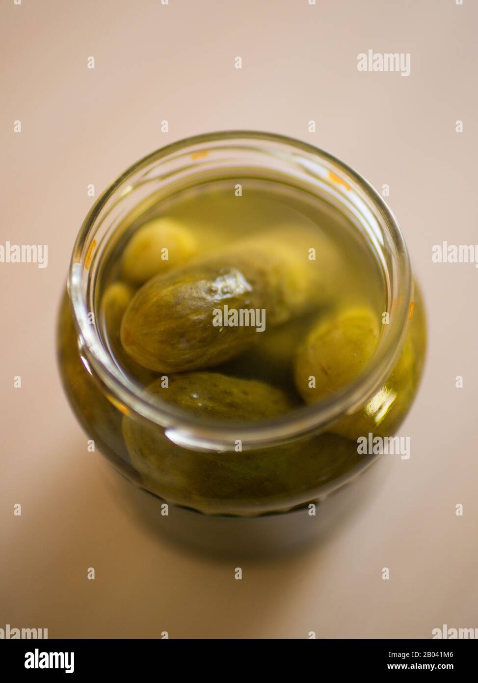 Pickled cucumbers in open jar close-up on the table Stock Photo
