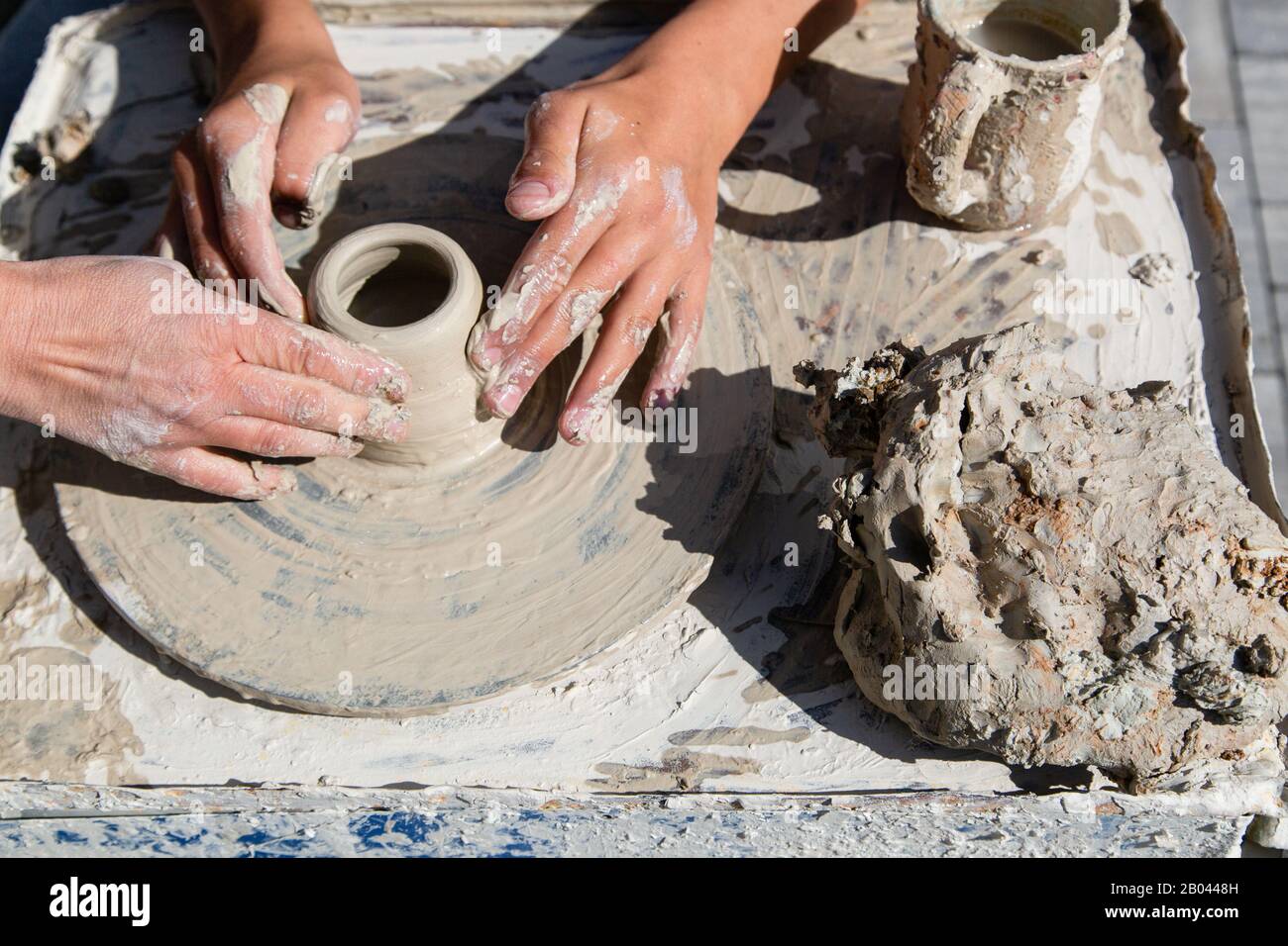 Teaching in masterful studio of ceramics works with clay on a potter's wheel Stock Photo