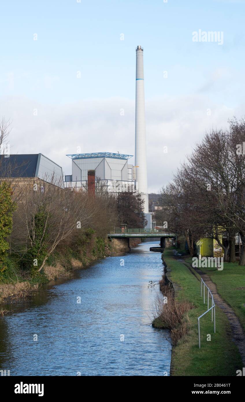 The chimney of Kirklees waste incinerator and CHP power station seen along Huddersfield Broad Canal, West Yorkshire, England, UK Stock Photo