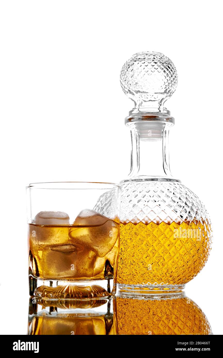 Bottle and glass with alcoholic drink with ice, on the rocks, whisky, rum, cognac, brandy, scottish, white background reflection Stock Photo