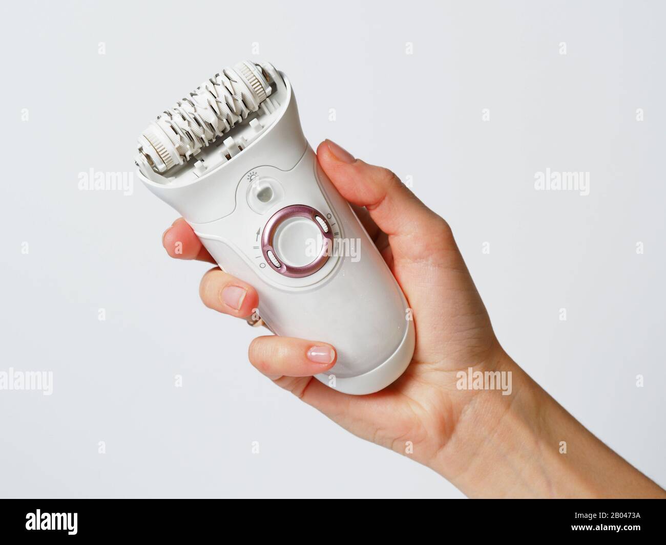 Female epilator white in a female hand on a white background. Electric hair  removal device. Concept of skin care and female beauty. Women's suffering  Stock Photo - Alamy