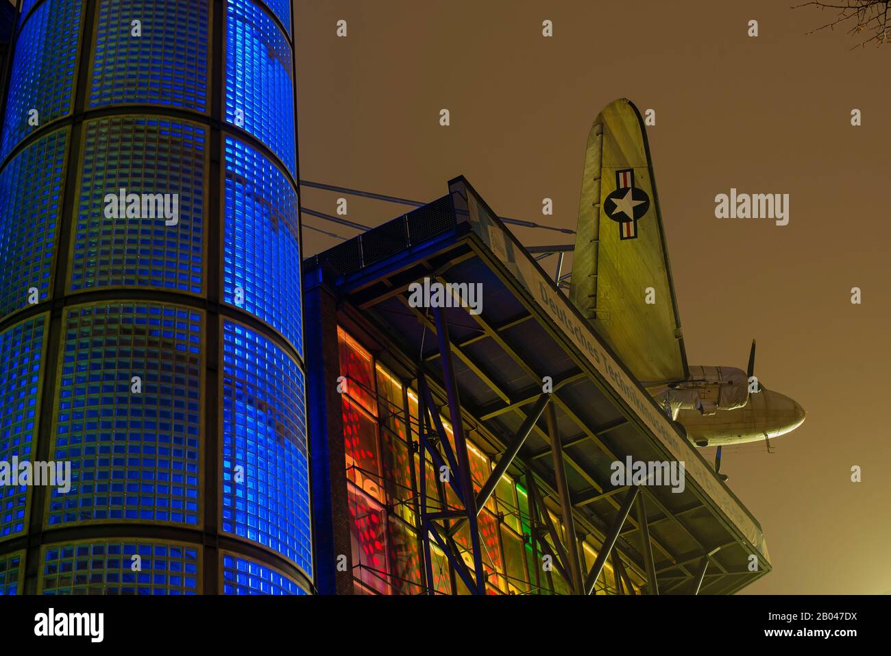 Facade of the German Technology Museum in Berlin, Germany at night, plane, colorful Stock Photo