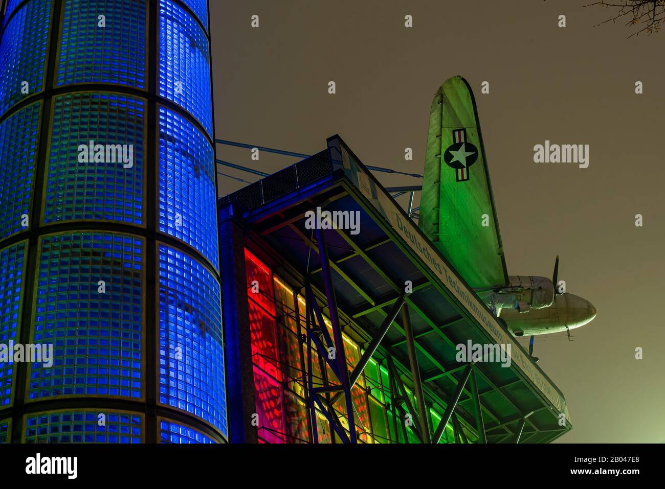 Facade of the German Technology Museum in Berlin, Germany at night, plane, colorful Stock Photo