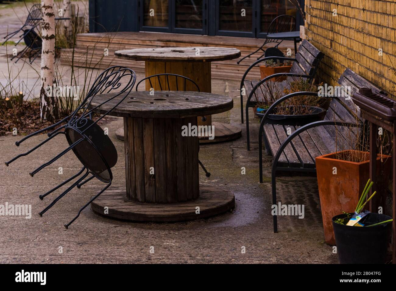 An old cable drum as a table, chairs and tables in the rain, café Stock Photo