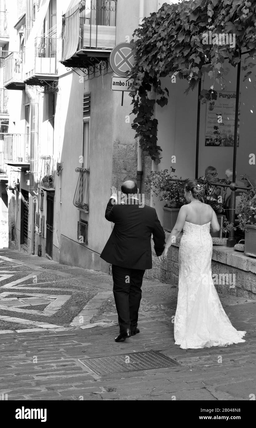 newlyweds in wedding dresses in the historic center of the village September 28 2019 Cefalu Italy Stock Photo