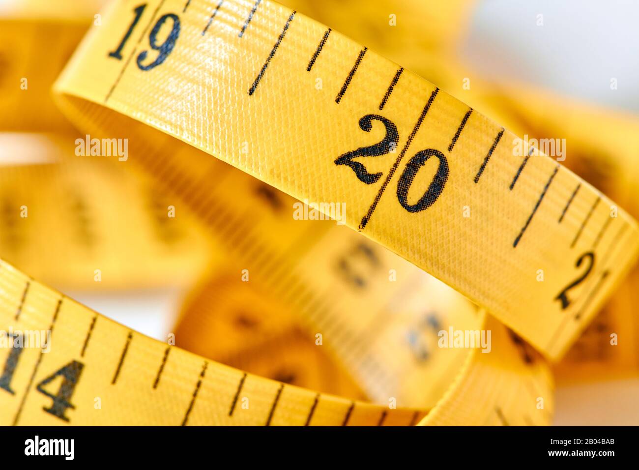 Tailors tape measure cut out against a white background. Yellow measuring  tape Stock Photo - Alamy