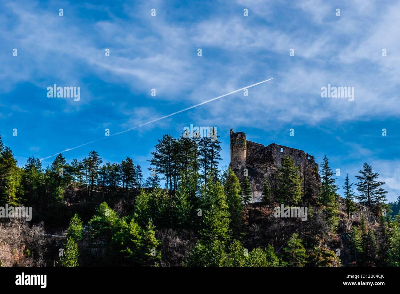 Picturesque castle of Guillaumes on a mountain in the French Alps with some forest and clear blue sky Stock Photo