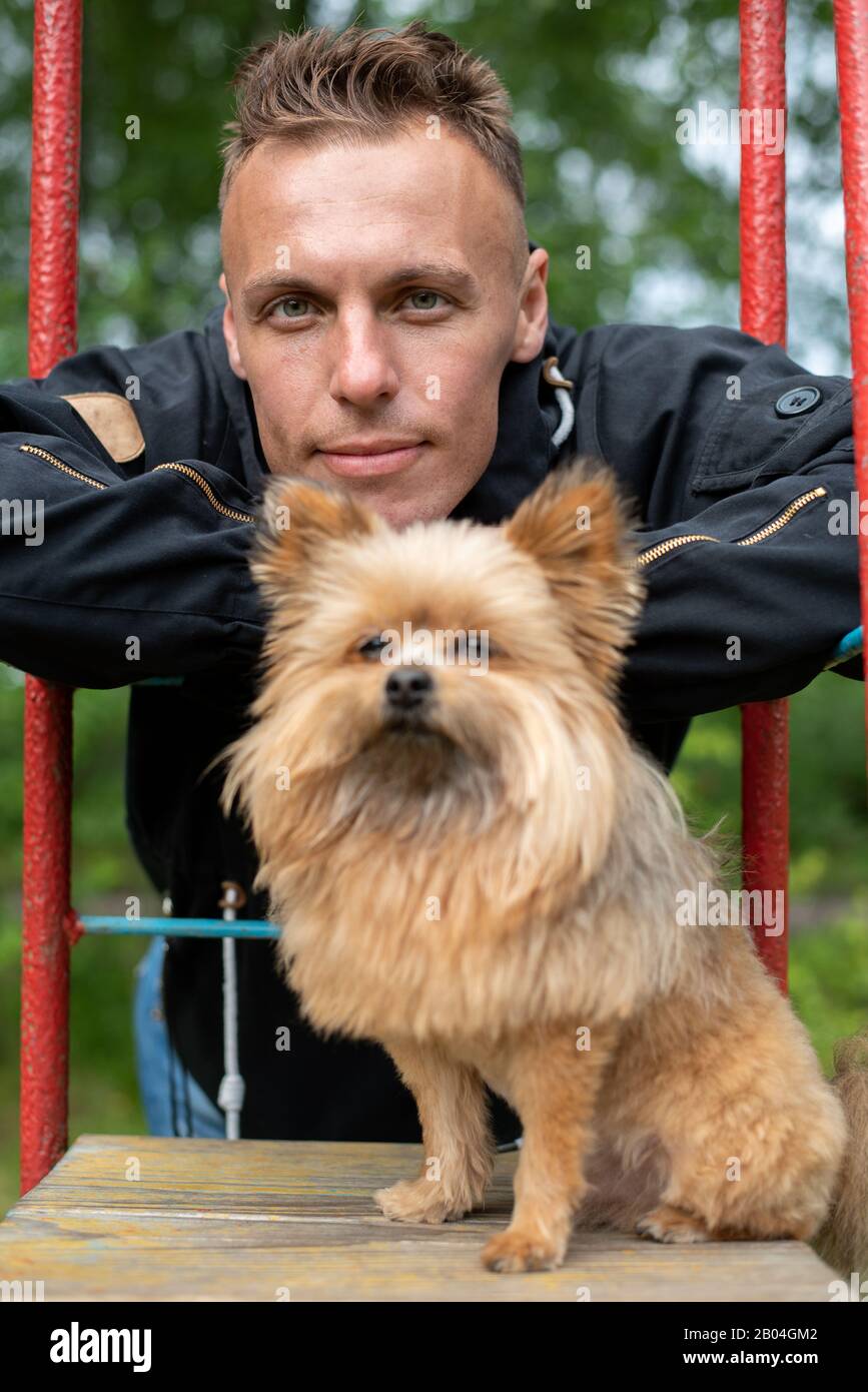 A man with a little dog on a swing. Stock Photo