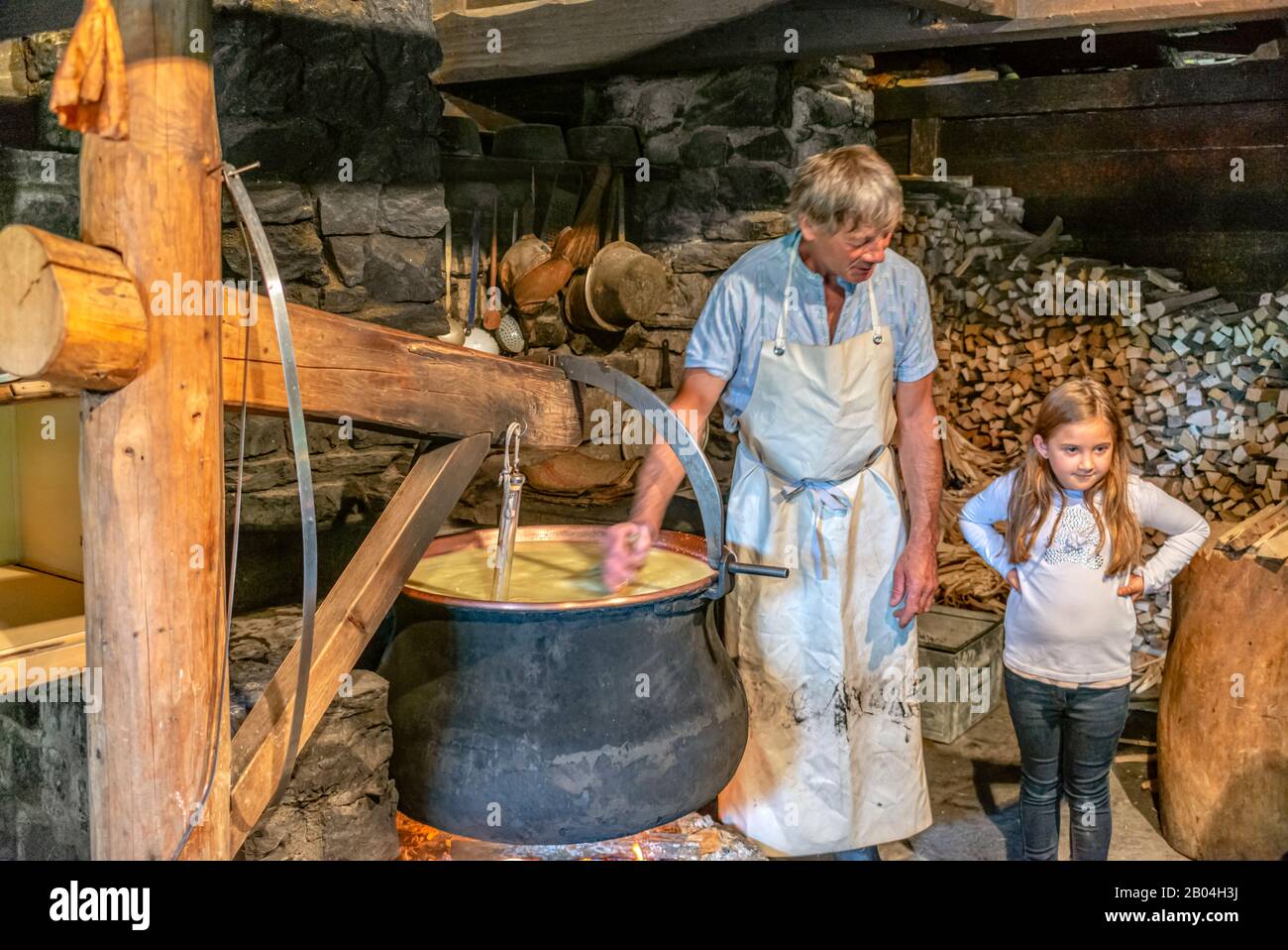 Cheese maker with a child in a cheese dairy at the Open Air Museum Ballenberg, Bern, Switzerland. Stock Photo