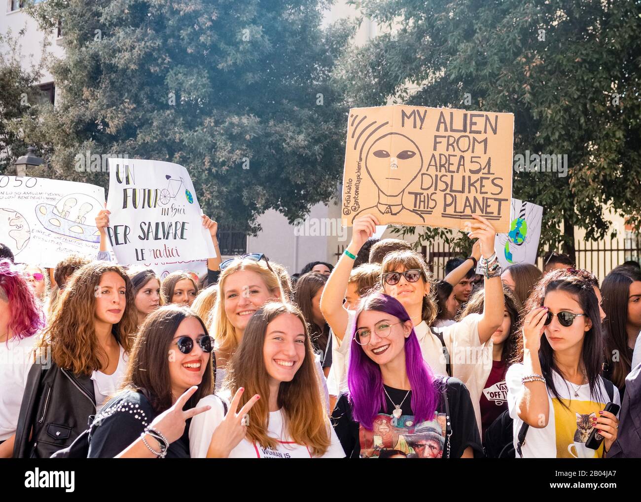 A procession made up of many young students protesting against climate change by displaying placards and banners with messages. Stock Photo