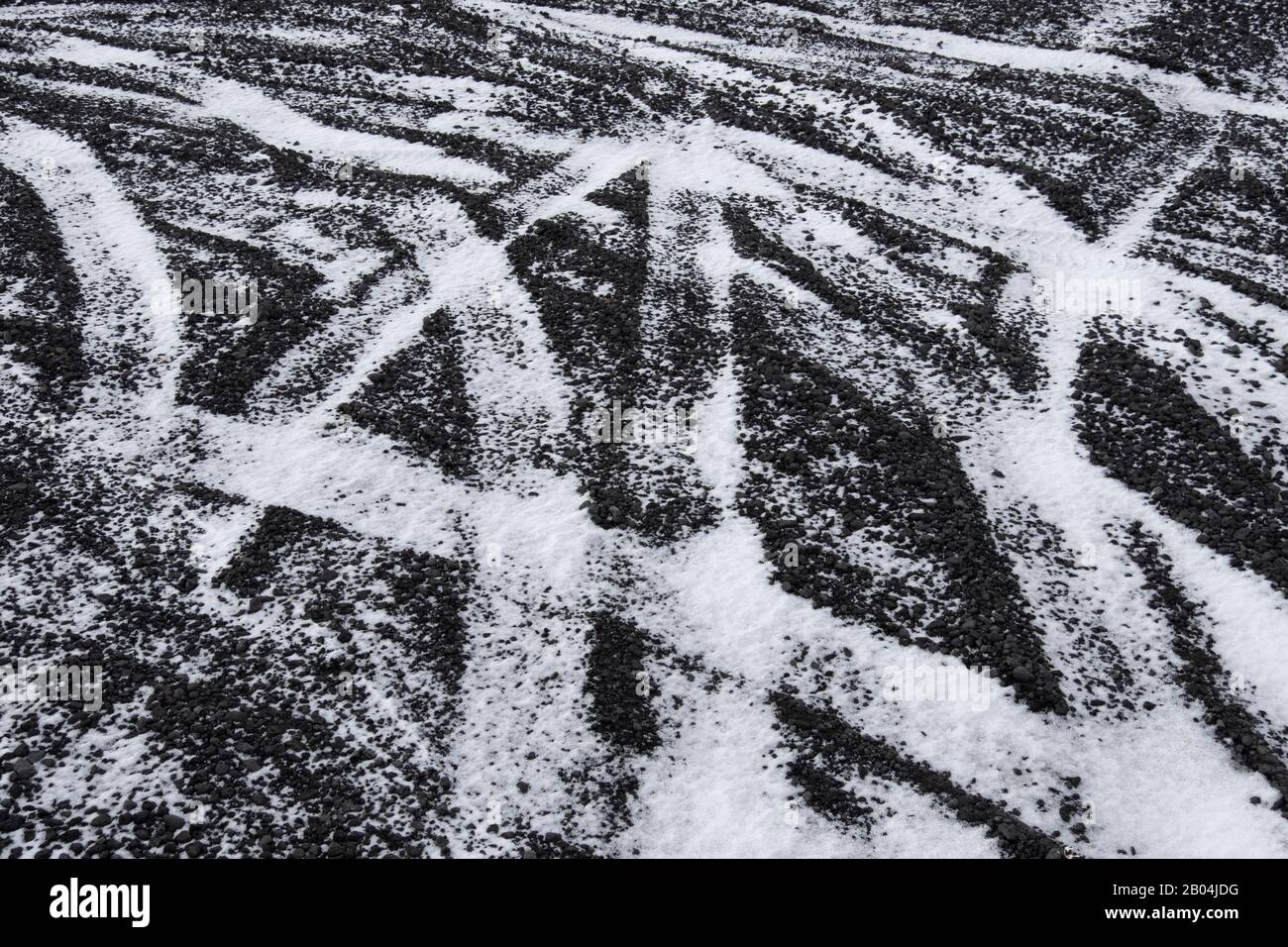 Tyre tracks on snowy basalt road in Iceland Stock Photo