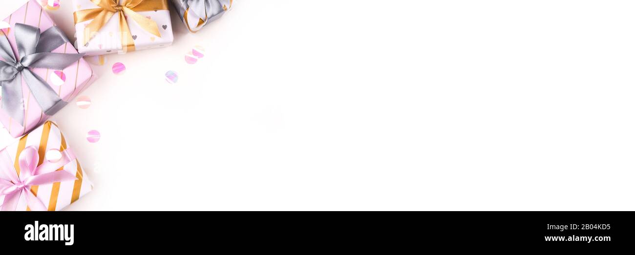 Several gift boxes with bows and confetti on a white background. Stock Photo