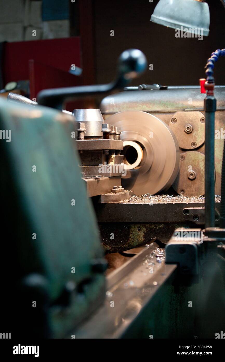 closeup of metallic lathe working against factory industrial interior background, nobody Stock Photo