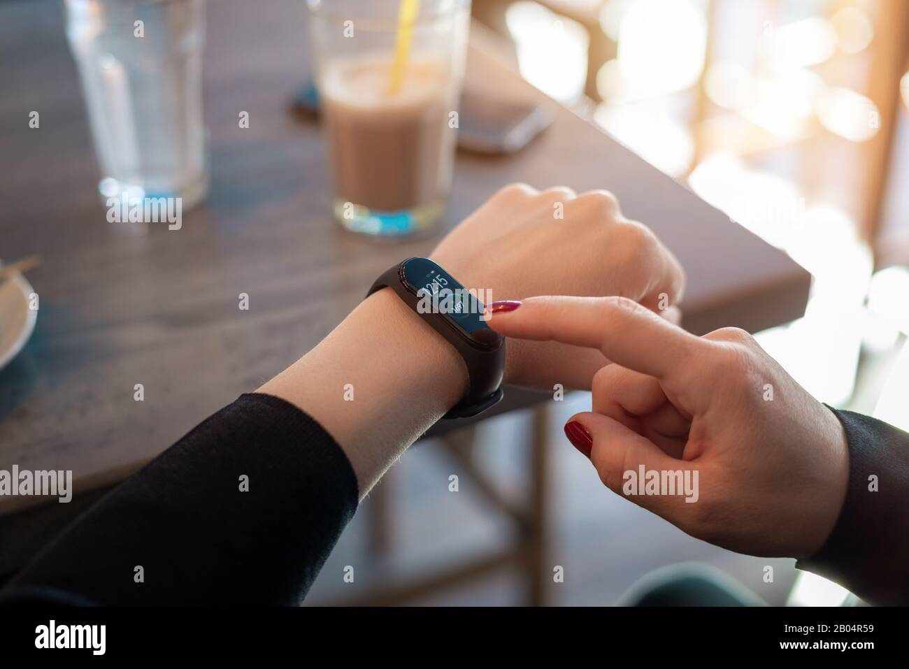 Girl uses apss on her smart band to view health parameters Stock Photo