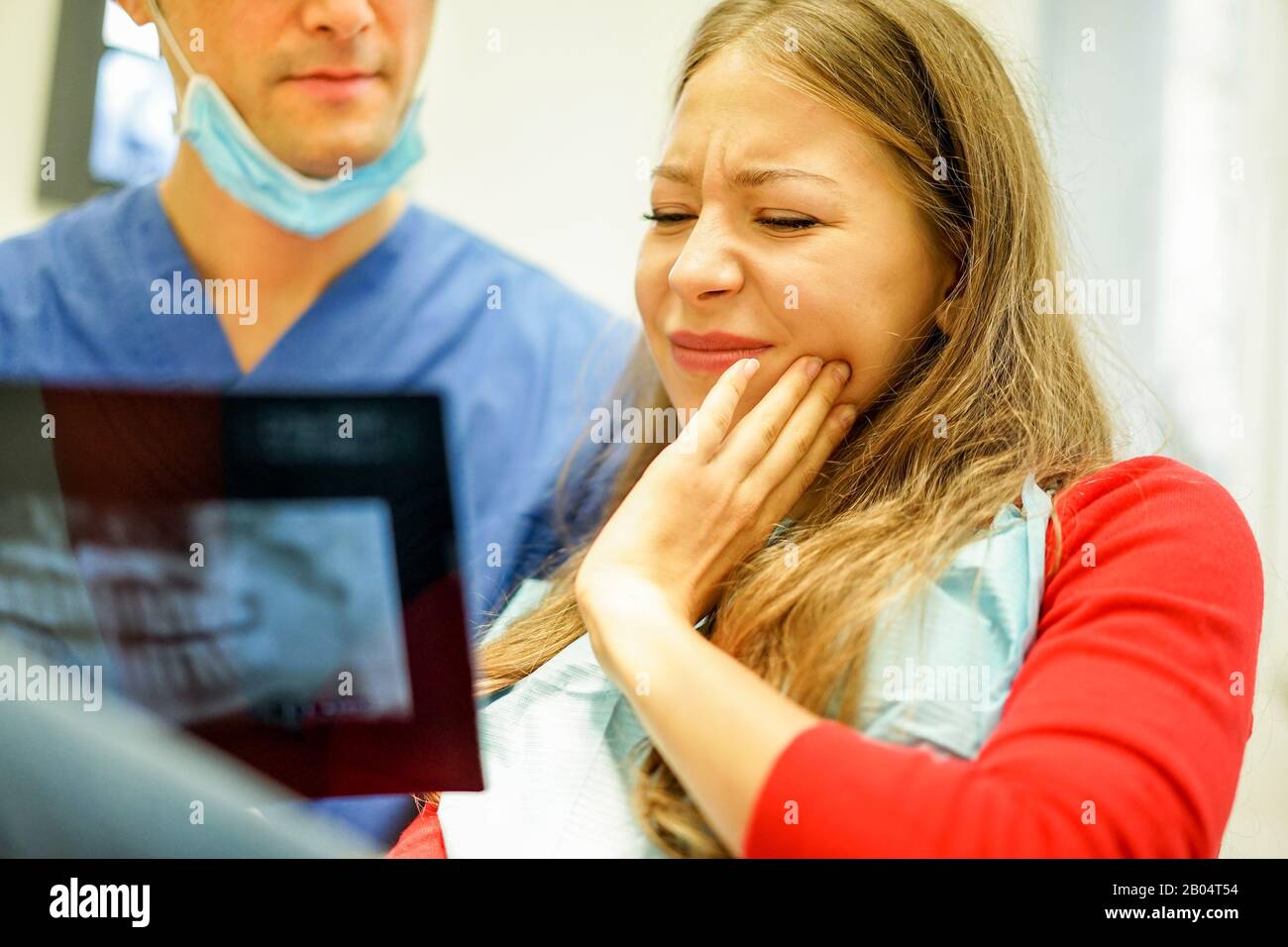Young woman with teeth pain looking xray in dental clinic with her