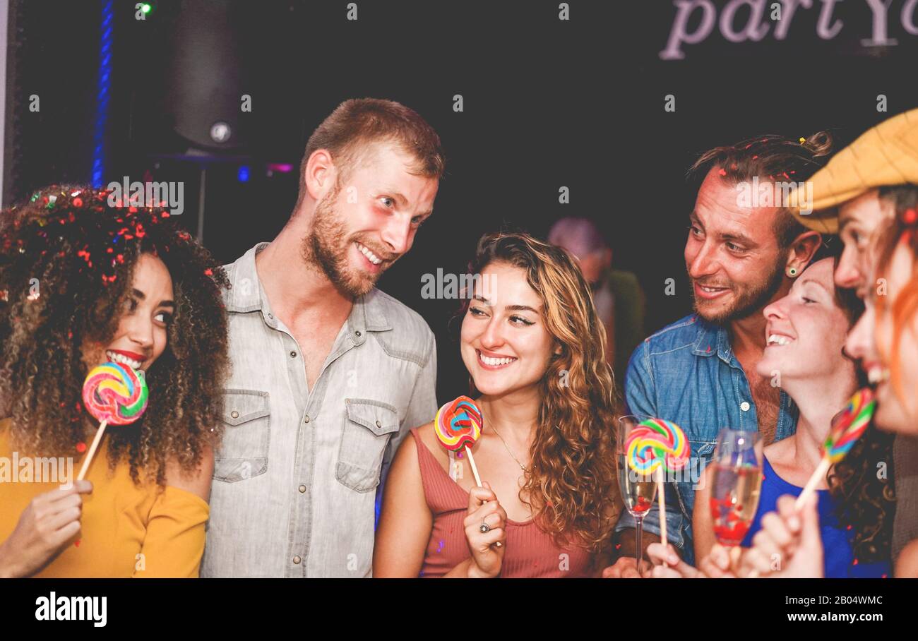 Young people dancing and drinking champagne at confetti party night
