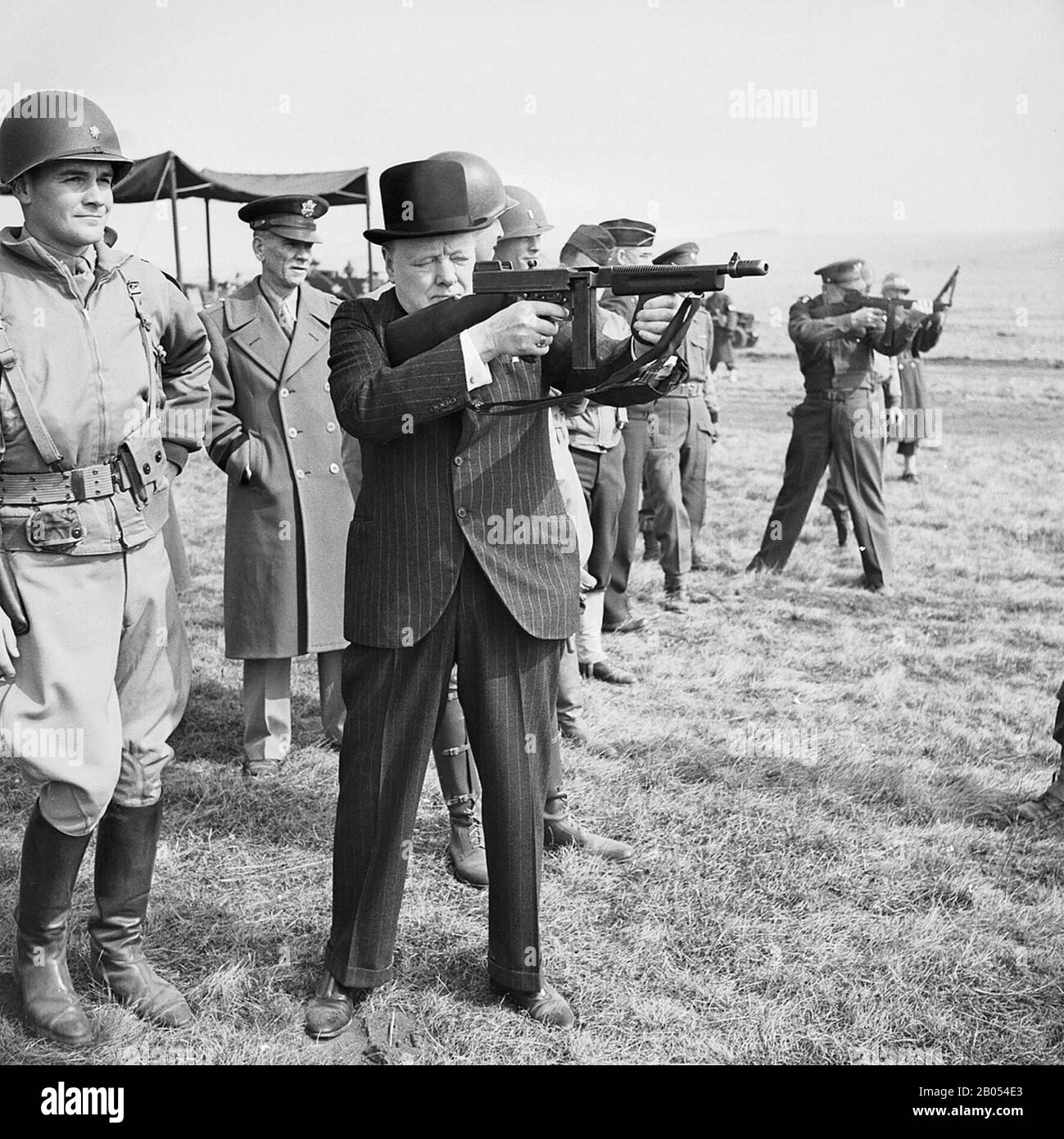 WINSTON CHURCHILL (1874-1965) firing a Thompson submachine gun alongside General Dwight Eisenhower  at right, during an inspection of American invasion forces in southern England in March 1944. Stock Photo