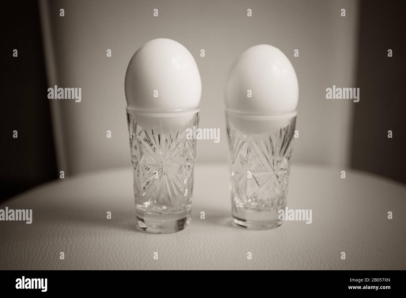 Two boiled chicken eggs in a crystal glasses on the table Stock Photo