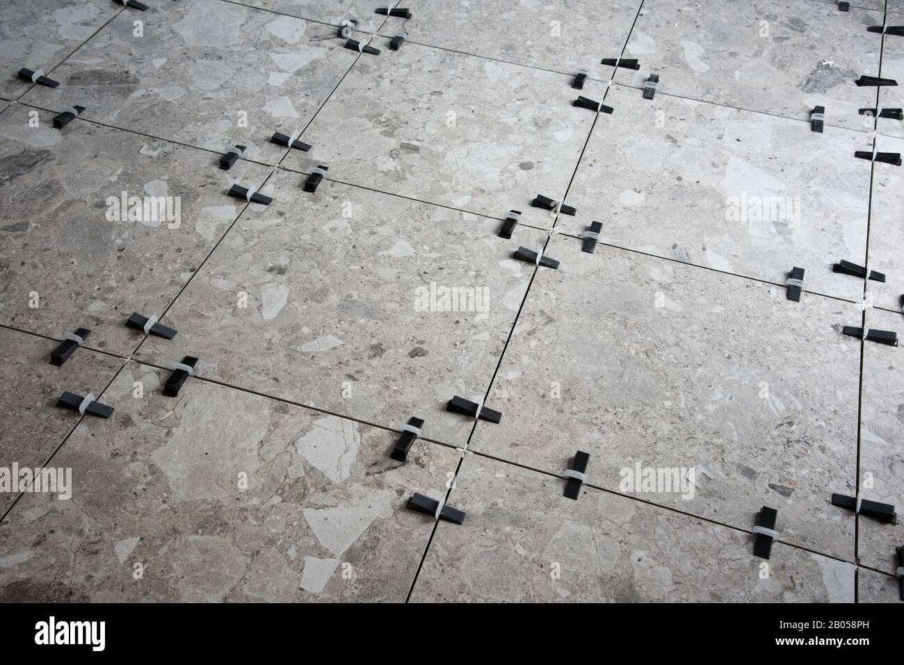 Plastic wedges and clips used for leveling ceramic tiles during installation of a floor. Stock Photo