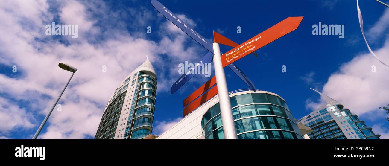 Directional sign in front of buildings, Sao Gabriel And Sao Rafael Towers, Parque Das Nacoes, Lisbon, Portugal Stock Photo