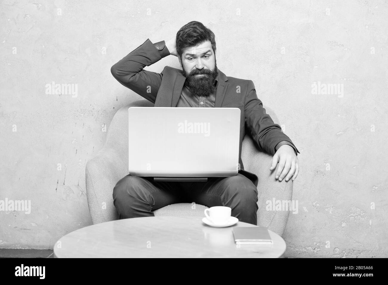 Watching blog for financial information. Businessman posting on online social network or blog at workplace. Bearded man writing new blog post in office. Blogger keeping his private blog. Stock Photo