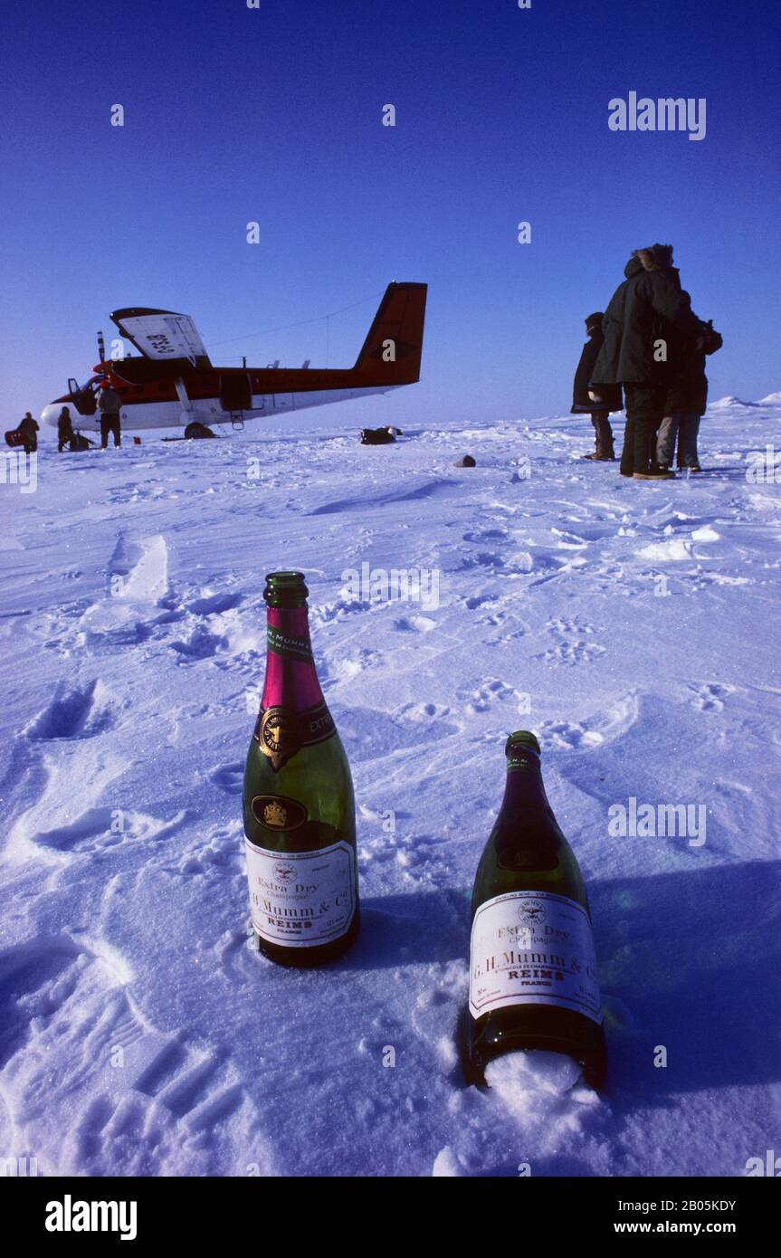 CANADA, NUNAVUT,  AT THE NORTH POLE TWIN OTTER WITH TWO BOTTLES OF CHAM- PAGNE IN FOREGROUND Stock Photo