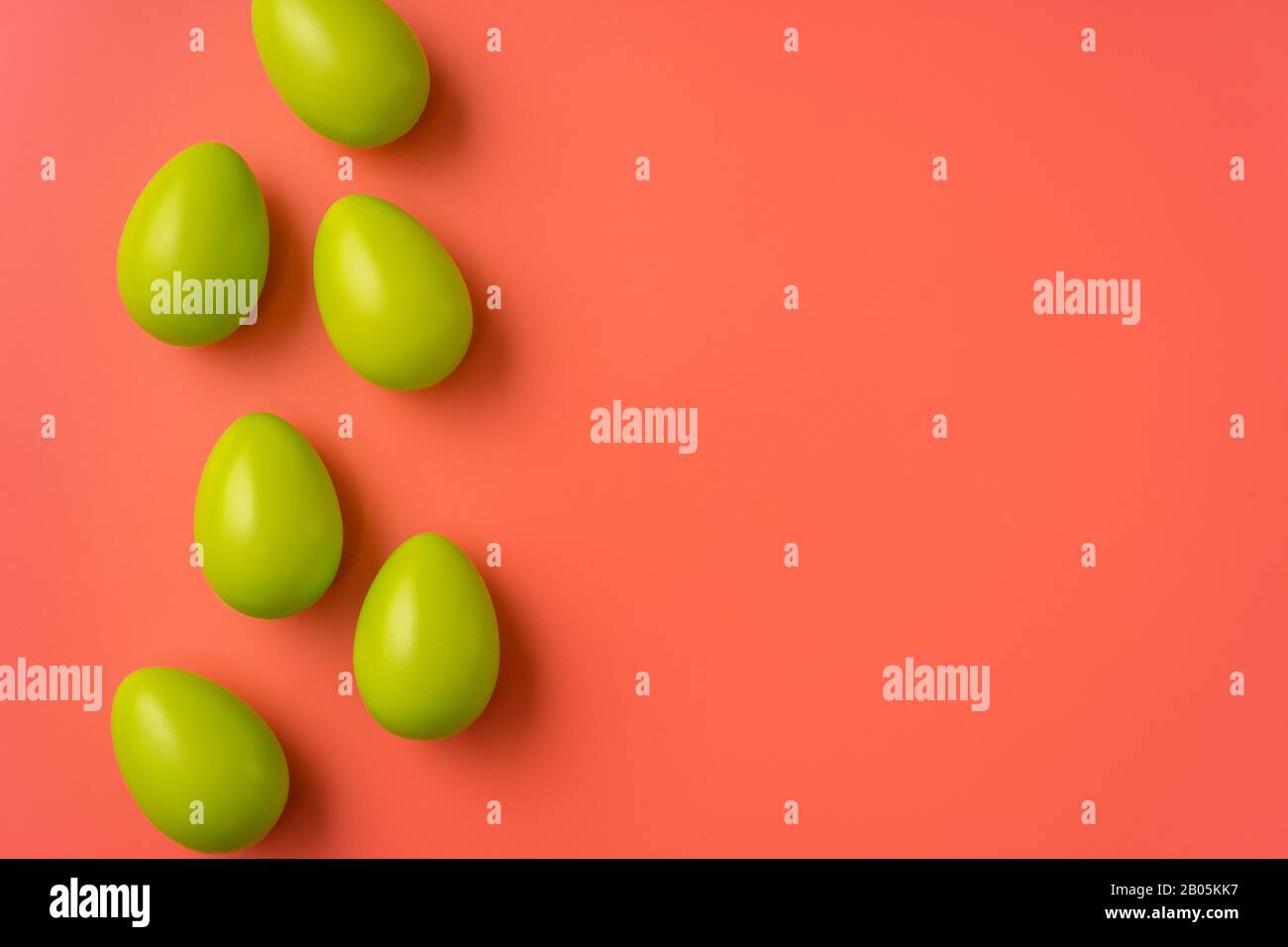 Easter concept. Simple composition with green eggs on vibrant orange background Stock Photo