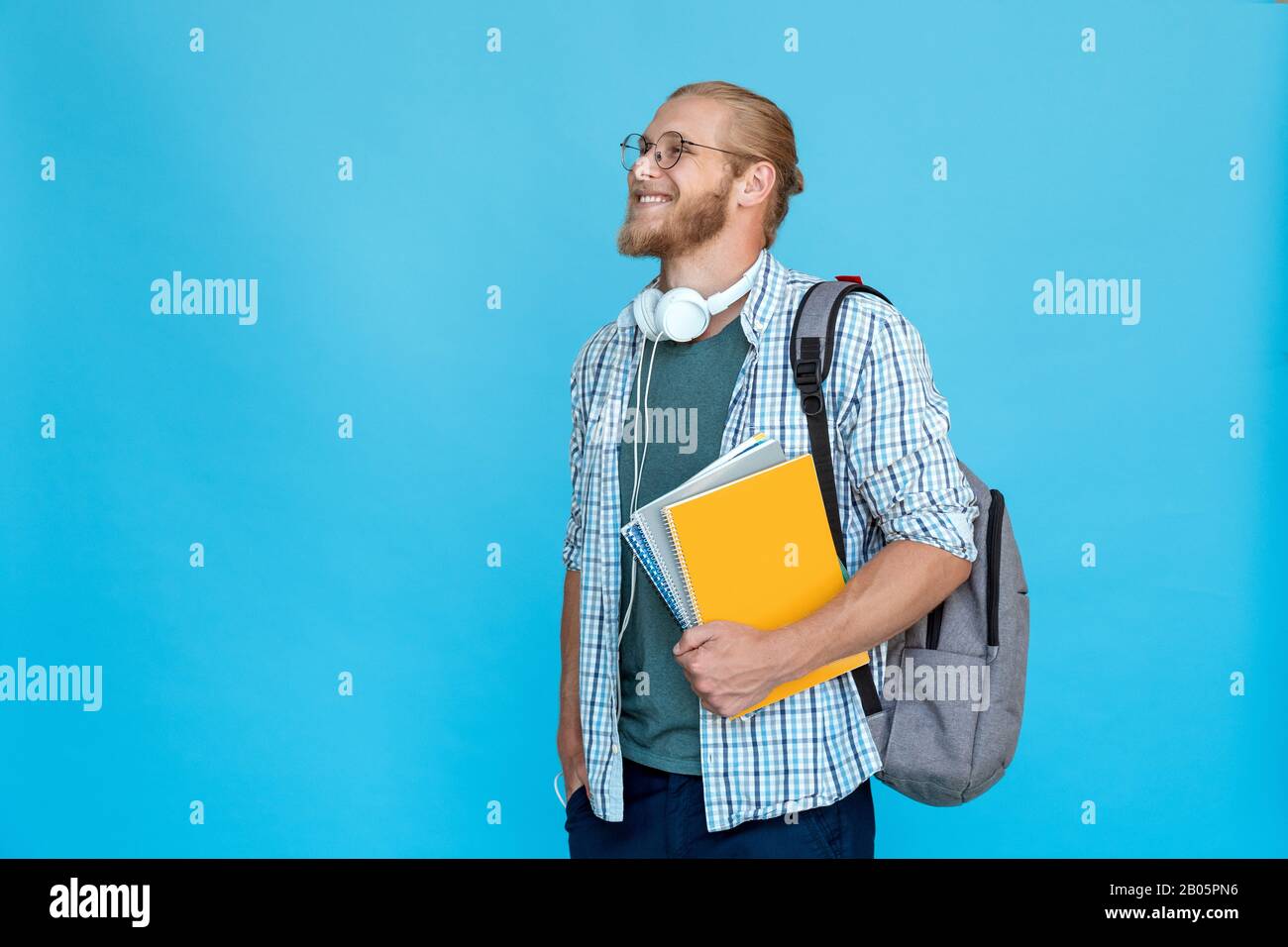 Profile young bearded college student hold notebooks backpack look at copy space Stock Photo