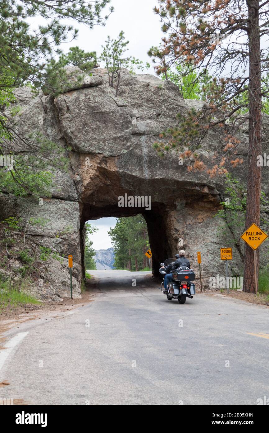 KEYSTONE, SOUTH DAKOTA - June 27, 2014: A motorcycle drives through Scovel Johnson tunnel on Iron Mountain Road with views of Mount Rushmore in Keysto Stock Photo