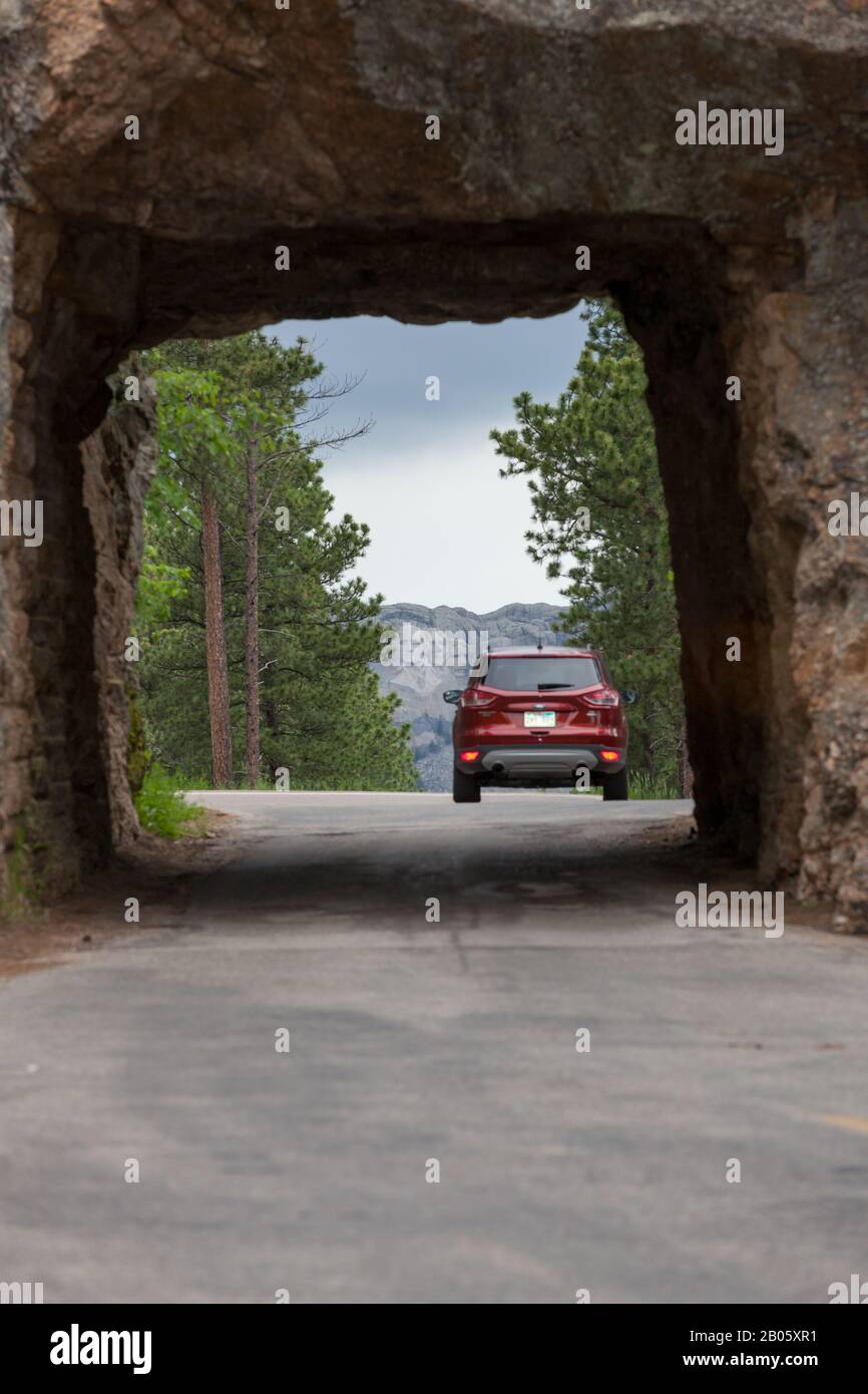 KEYSTONE, SOUTH DAKOTA - June 27, 2014: A car drives through Scovel Johnson tunnel on Iron Mountain Road with views of Mount Rushmore in Keystone, SD Stock Photo