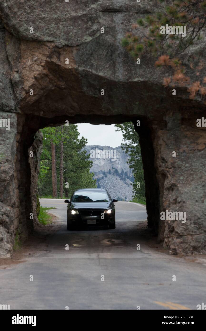 KEYSTONE, SOUTH DAKOTA - June 27, 2014: A car drives through Scovel Johnson tunnel on Iron Mountain Road with views of Mount Rushmore in Keystone, SD Stock Photo