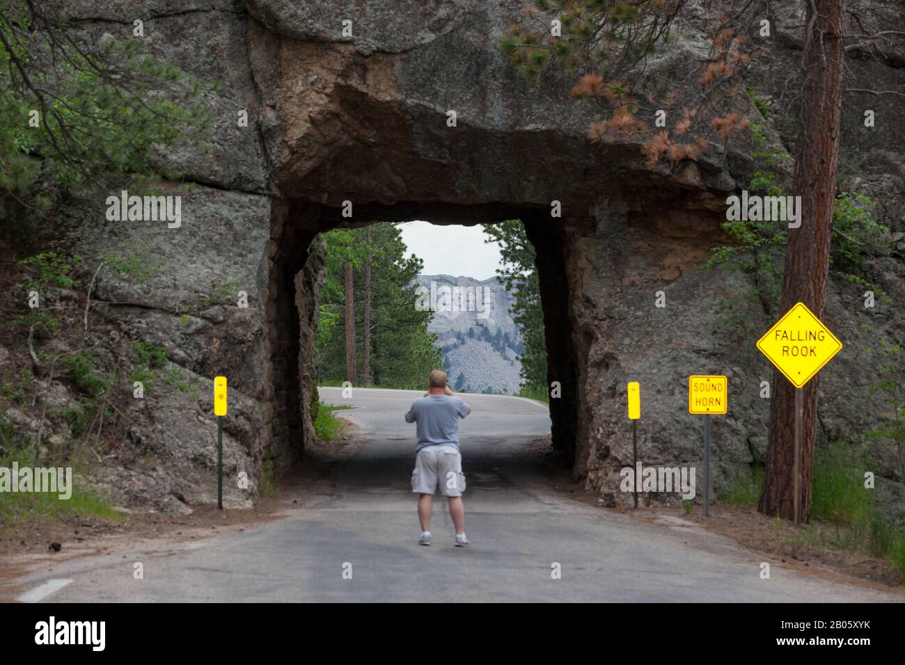 KEYSTONE, SOUTH DAKOTA - June 27, 2014: A tourist takes pictures through the Scovel Johnson tunnel on Iron Mountain Road with views of Mount Rushmore Stock Photo